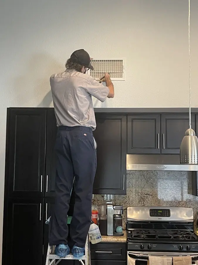 Technician inspecting an air vent during HVAC service in Yonkers